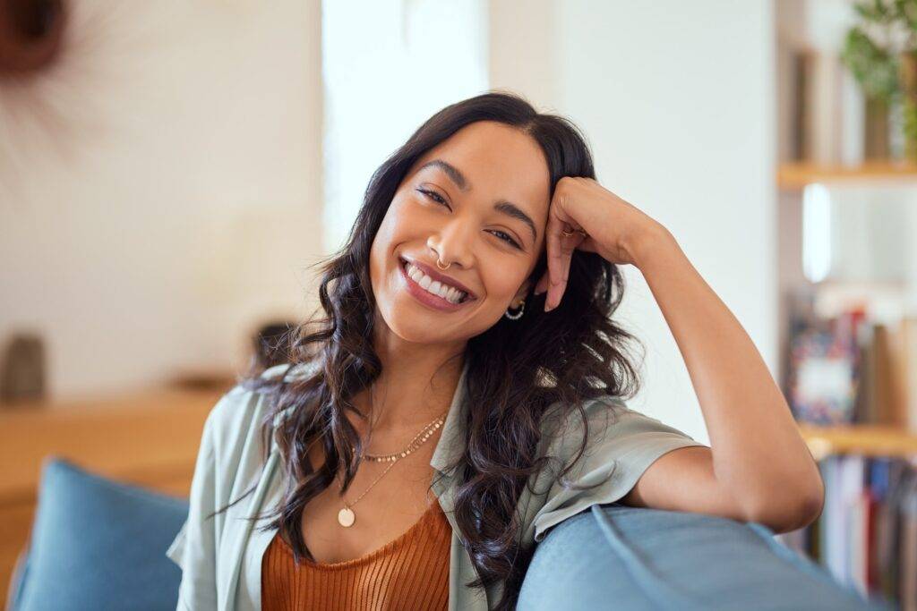 Smiling woman with dark hair and a nose ring, embodying the diverse clientele served at Dr. Kevin Burgdorf's dental practice.