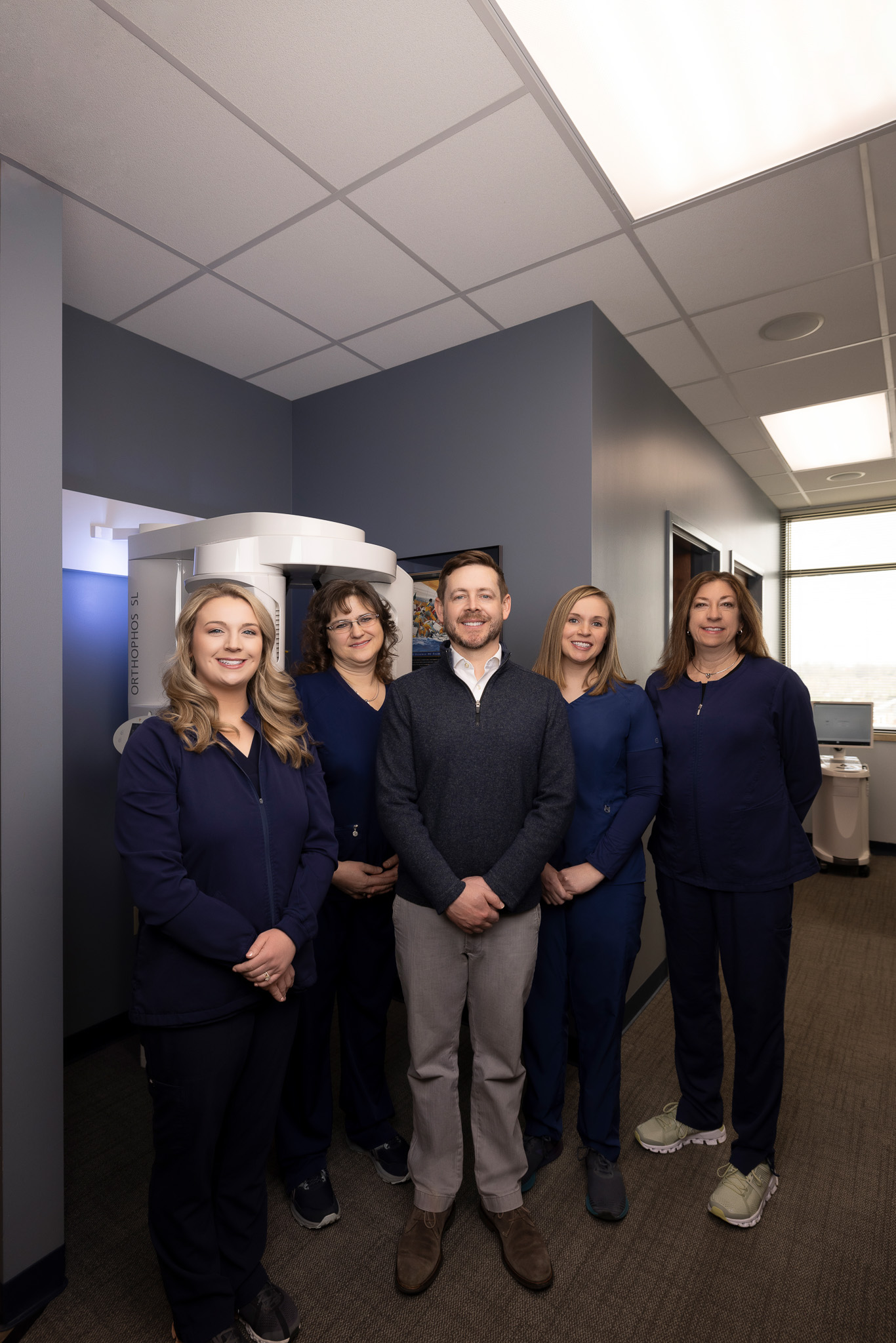 Portrait-oriented team photo at Dr. Kevin Burgdorf's dental practice, showcasing the dedicated and professional staff.